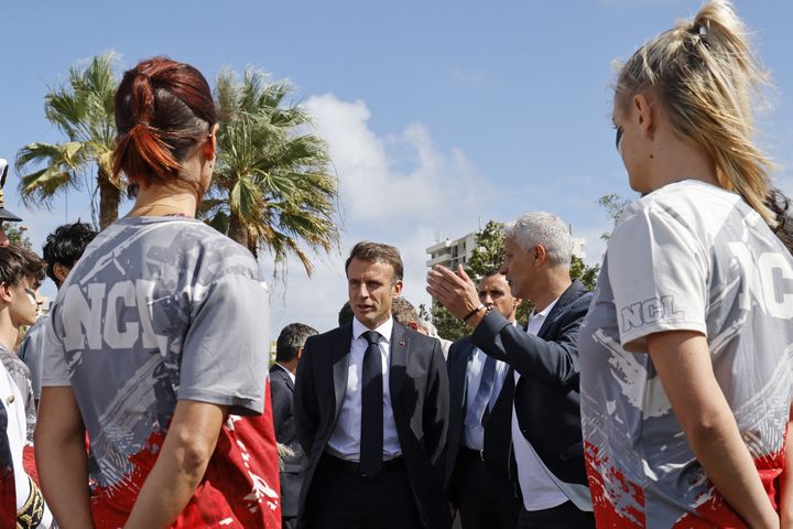 Le président français Emmanuel Macron discute avec des athlètes lors d'une visite dans la banlieue de Magenta à Nouméa, le 26 juillet 2023. (LUDOVIC MARIN / AFP)