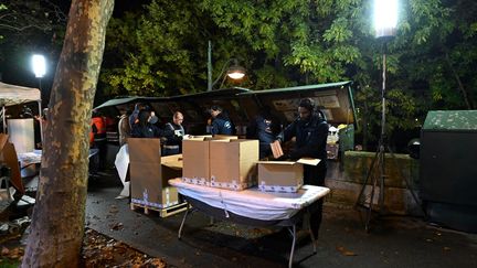 Des employés de la mairie de Paris emballent les livres des bouquinistes avant une opération test de retrait des boîtes, le 17 novembre 2023 à Paris. (MIGUEL MEDINA / AFP)