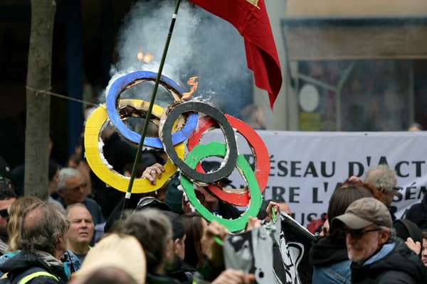 Des manifestants brûlent des anneaux olympiques en carton lors de la manifestation annuelle du 1er-Mai, à Paris, le 1er mai 2024.